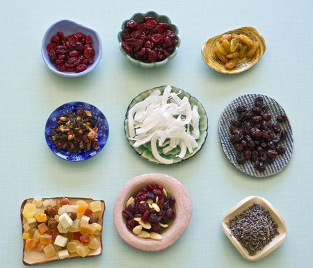 assorted dry fruits cut to squares for seasoning in a square ceramic bowl on retro backgroundの写真素材