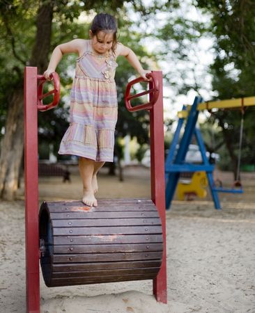 girl on a Walking Barrel in a playgroundの写真素材