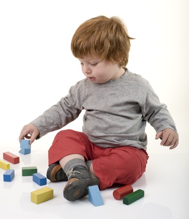 red head boy playing with building blocksの写真素材