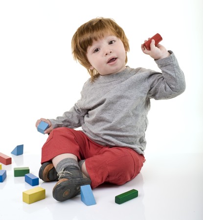 red head boy playing with building blocksの写真素材