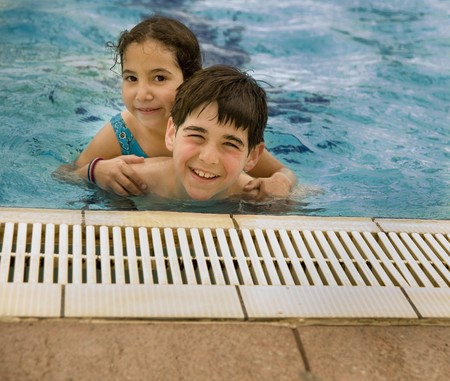 Boy carrying girl by piggyback in the poolの写真素材