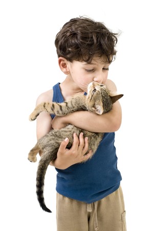 young boy holding and kissing a kittenの写真素材