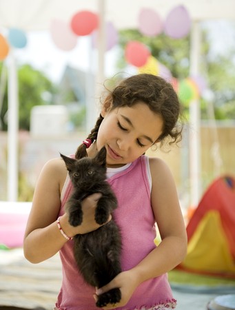 little girl holding a black kitten の写真素材