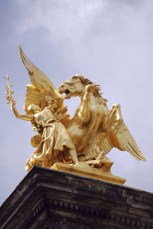 golden statue in paris, on one of the famous bridgesの写真素材