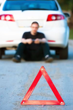 Car accident on a road. Focus is on the red triangle sign