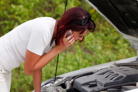 Adult caucasian woman in her car breaks down. Engine failure.