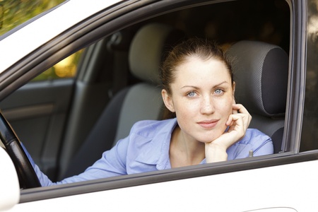 Pretty female driver in a white car