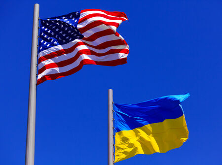 flags of the USA and Ukraine against bright blue skyの写真素材