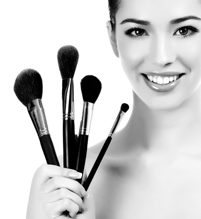 Female with cosmetic brushes, white background, copyspaceの写真素材