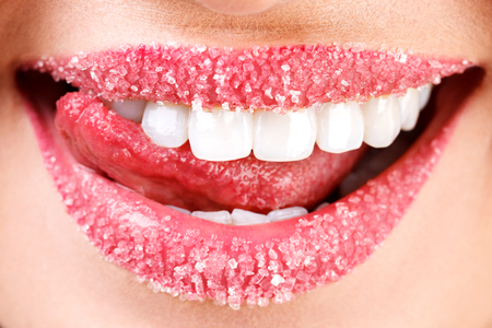 Closeup of woman's lips covered with sugar. Toothy smileの写真素材