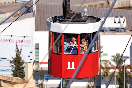 15 September 2011 Barcelona, Spain: Group of tourists in the red cable car on cable-way above the city of Barcelonaのeditorial素材