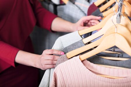 Closeup shot of hands of woman who choosing new clothes, fashion shop conceptの写真素材