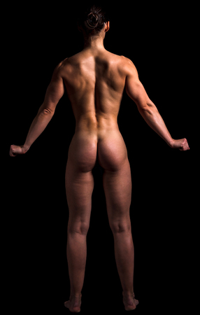 Naked bodybuilder woman is posing against black background, isolatedの写真素材