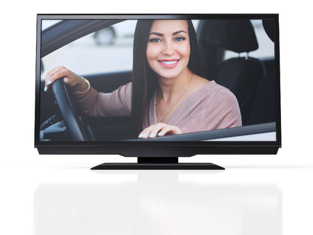 Happy owner of a new car on a screen of black LED monitor. Smiling young pretty woman sitting in her...