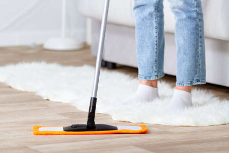 Housewife cleans the floor with a mop