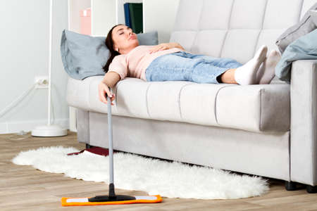 Woman resting on the sofa after cleaning a floorの写真素材