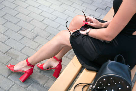 Long legged woman sitting on a benchの写真素材