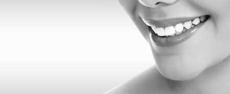 Pretty woman smiling against a grey background with copyspaceの写真素材