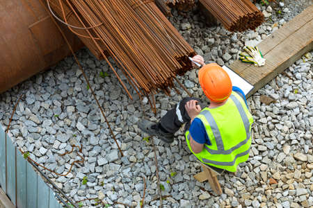 Worker making marks on metal reinforcement bars