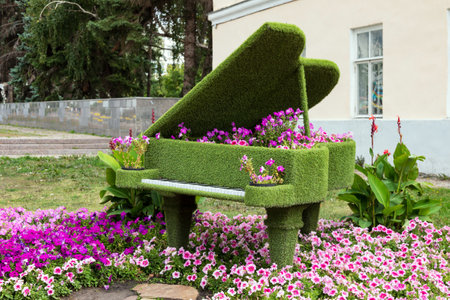 Piano in the garden of the house with a flower bed.の写真素材