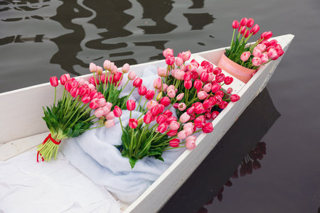 Bouquet of pink tulips in a boat on the waterの写真素材