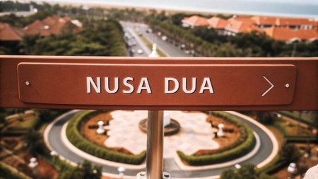 A directional sign points the way to Nusa Dua a renowned resort area in Bali Indonesia amidst lush tropical greenery and modern buildings for an ideal travel experience.の素材
