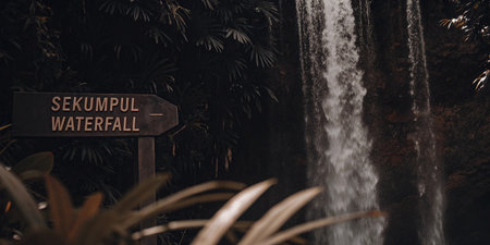 A weathered wooden sign directs adventurers to Sekumpul Waterfall, a stunning natural wonder hidden amidst Balis lush tropical jungle. Discover the path to this beautiful cascade.の素材