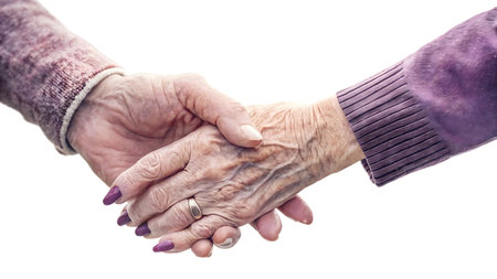 This image shows the gentle clasp of two hands, highlighting the power of human connection, support, and care. An elderly hand is tenderly held, offering a moment of comfort, empathy, and reassurance. It's a beautiful symbol of compassion.の素材