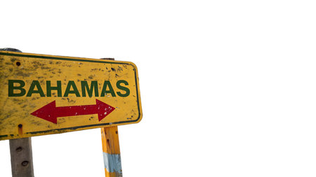 A charming, weathered yellow road sign with a distinctive red arrow clearly points the way to the tropical paradise of the Bahamas. This rustic indicator suggests an exciting journey to sun-drenched beaches and ocean adventures, hinting at a perfect islanの素材
