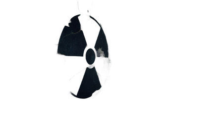 A distressed and fragmented radiation warning symbol breaks apart against a dark, atmospheric background, evoking themes of danger, decay, and environmental crisis.の素材
