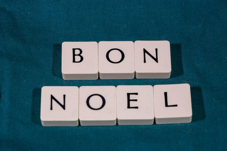 Greeting text "Happy Christmas" written with board game chips on a green background (Happy Christmas is Happy Christmas written in French)の写真素材