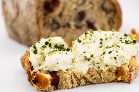 Fresh goat cheese slices with herbs garlic and chopped mustots on a slice of bread with cereals and...