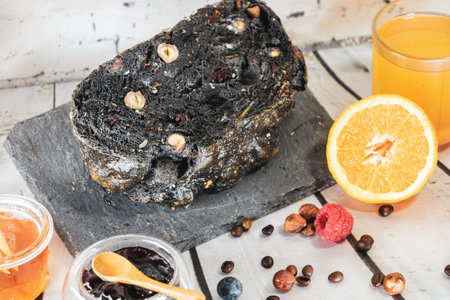 Black bread with raisins and orange juice on wooden table