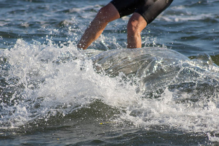 Man jumping into the water with splashes of water in the background