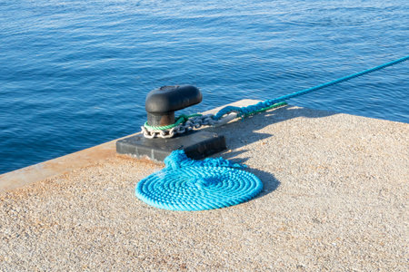 Mooring bollard with rope on a pier in the sea