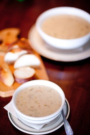 closeup of bowl of hot soup with fresh bread and another bowl in the background, shallow DOF
の写真素材