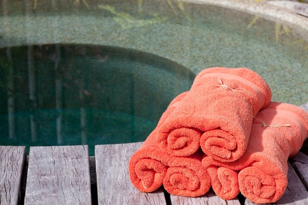 wrapped orange towels by the private poolの写真素材