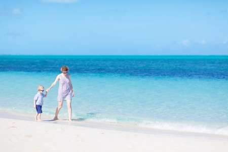mother and her son strolling at the caribbean beachの写真素材
