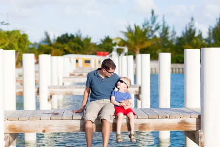 handsome young man hugging his son at the moorageの写真素材