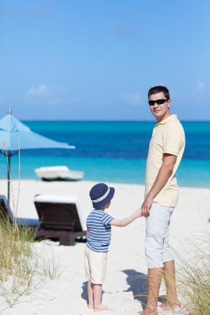 handsome young man and his son at the caribbean beachの写真素材