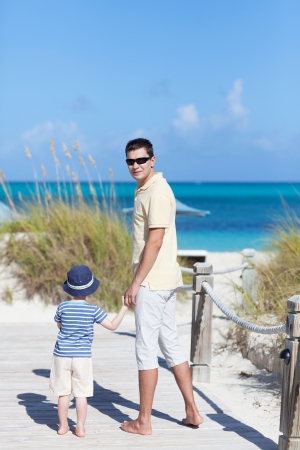 smiling handsome young man with his son at the caribbean beachの写真素材