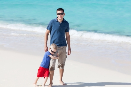 handsome smiling father and his son at the caribbean tropical beachの写真素材