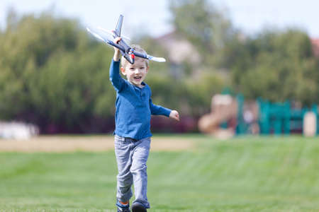 excited little boy running with a toy planeの写真素材