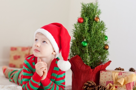 cute caucasian boy dreaming about presents at christmas timeの写真素材