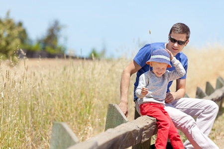 young caucasian father and his laughing son resting after hikingの写真素材
