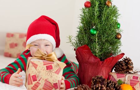 cheerful excited little boy with a gift box at christmas time の写真素材