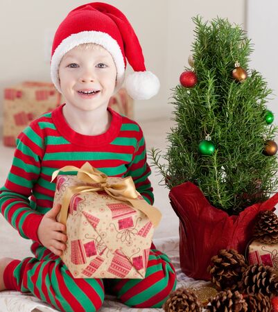 happy smiling excited boy with a christmas giftの写真素材