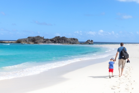young father and his son walking at the perfect caribbean beach at middle caicosの写真素材