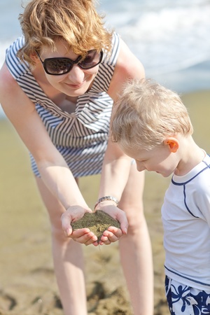 happy mother and her excited son exploring green sand at papakolea beach at big island, hawaiiの写真素材