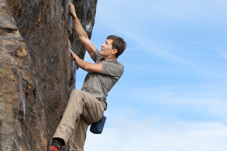 handsome young man bouldering or rock climbing outdoorsの写真素材